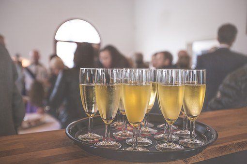 Champagne glasses on a tray - Christmas Party Perils for Employers